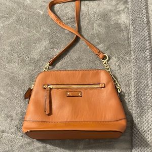 Small, faux leather cross body bag with accent chains.